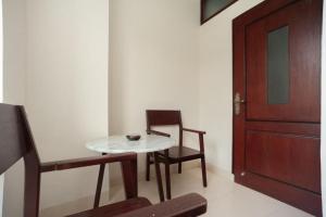a table and chairs in a room with a door at Bethara Hotel Syariah Lampung in Tanjungkarang
