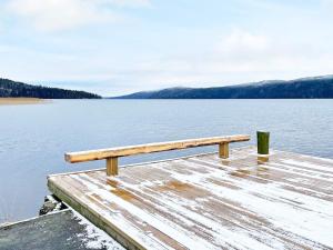 a bench sitting on top of a dock on a lake at 6 person holiday home in STRA NTERVIK in Östra Ämtervik