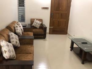 a living room with two couches and a table at Home Away From Home in Chittagong