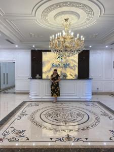 ハロンにあるNew Ha Long Hotel - by Bay Luxuryのシャンデリアのある広い部屋に立つ女性