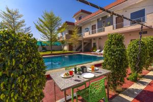 a backyard with a table and a swimming pool at Zostel Homes Pushkar in Pushkar