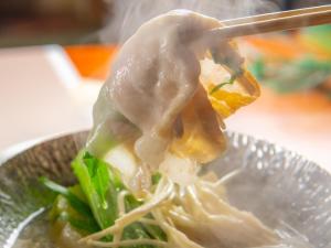 a bowl of noodles and vegetables with a chopstick at Yumotoya in Matsumoto