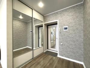 an empty room with glass walls and wooden floors at Новостройка с красивым видом 9 этаж in Petropavlovsk +6 photos