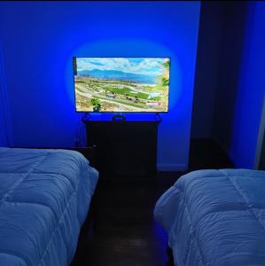 a blue room with a tv and two beds at Mountain Escape in Squaw Valley