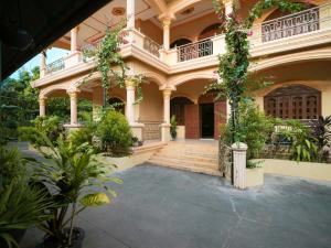 貢布的住宿－Villa Kampot Cafe，一座大建筑,有楼梯和植物