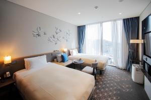 Hotel Gracery Seoul في سول: غرفه فندقيه سريرين وتلفزيون
