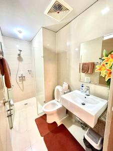 een badkamer met een wastafel, een toilet en een douche bij Two Palm Tree Villas in Manilla