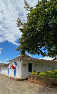 a white house with a flag on the side of it at El Principito Hospedaje in Barichara