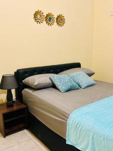 蒙特哥贝The Rest Stop-B- 15 min from Airport/24hrs Security的一张带两个枕头的床和墙上的时钟