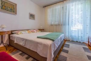 ein Schlafzimmer mit einem Bett und einem großen Fenster in der Unterkunft Apartments Kamen in Dramalj
