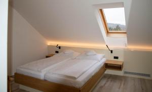 - une chambre avec un grand lit et une fenêtre dans l'établissement Pension Christine, à Großweikersdorf