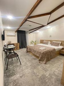 Un dormitorio con una cama y una mesa. en Hotel Traveler en Sighnaghi