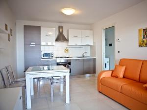 a kitchen and living room with a table and a couch at Costa Azzurra Residence in Grado