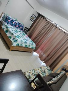 uma sala de estar com uma cama e um sofá em Condotel Near Airport at Two Palmtree Villas em Manila