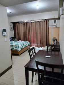 uma sala de estar com uma mesa de jantar e um quarto em Condotel Near Airport at Two Palmtree Villas em Manila