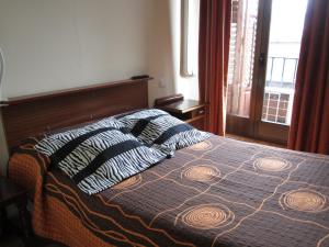 a bed with two pillows on it in a bedroom at Pensión Mollo in Madrid