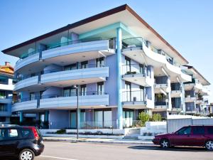 a building with cars parked in front of it at Costa Azzurra Residence in Grado