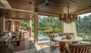a patio with a table and chairs and a pool at Four Seasons Resort Bali at Sayan in Ubud