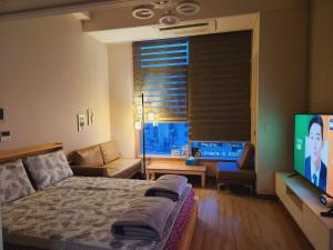 a bedroom with a bed and a flat screen tv at Y stay in Daegu