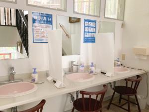 a bathroom with two sinks and two mirrors at Pension Todoroki in Atami