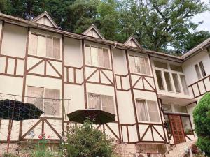 un edificio con dos sombrillas delante en Pension Todoroki, en Atami