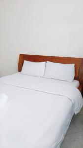 duże łóżko z białą pościelą i poduszkami w obiekcie sky furnished apartment in south b w mieście Nairobi