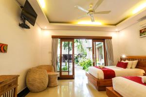 a bedroom with two beds and a ceiling fan at Amoya Inn in Ubud