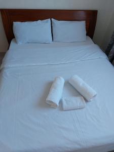 dwa ręczniki siedzą na białym łóżku w obiekcie sky furnished apartment in south b w mieście Nairobi