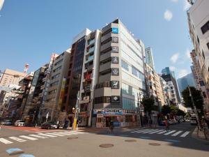 un edificio alto en una calle de una ciudad en Rembrandt Cabin & Spa Shimbashi - Caters to Men, en Tokio