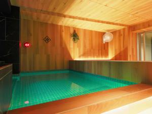 una piscina en una habitación de madera con en Rembrandt Cabin & Spa Shimbashi - Caters to Men, en Tokio