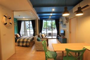 een woonkamer met een bank, een bed en een tafel bij บ้านแสนคราม หัวหิน Family Room - Pool Access ห้องติดสระ in Phetchaburi