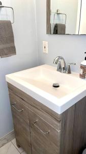 a bathroom with a white sink and a mirror at SPACE X ,LAX & Beaches Beautiful Guest House in Gardena