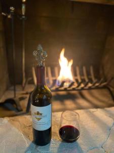 a bottle of wine and a glass on a table with a fireplace at SPACE X ,LAX & Beaches Beautiful Guest House in Gardena