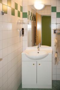 La salle de bains est pourvue d'un lavabo et d'un miroir. dans l'établissement Pension Christine, à Großweikersdorf