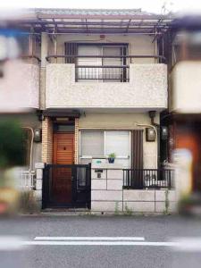 a house with a door and a balcony on a street at Osaka MISAKI Traditional Japanese house 2-6 ppl near station in Osaka