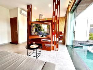 1 dormitorio con TV y piscina en Del Cielo Villa Seminyak, en Seminyak