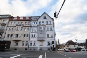 een wit gebouw in een stadsstraat met een verkeerslicht bij DWELLSTAY - Wohnung 90qm, 3 Schlafzimmer, Küche, Wohnzimmer, Balkon, Netflix in Fulda