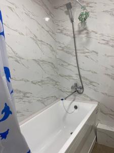 a bathroom with a shower with a bath tub at Уютная квартира-студия ЖК Теремки in Almaty