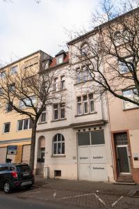 um edifício com um carro estacionado em frente em DWELLSTAY - Premium Wohnung I 95qm I 3 Schlafzimmer I großes Bad I Küche I Wohnzimmer I TV em Fulda