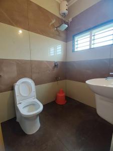 uma casa de banho com um WC e um lavatório em Green Palace Resort em Vagamon