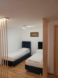 2 łóżka w pokoju z białymi ścianami w obiekcie Domki Krupa Chochołów w Chochołowie