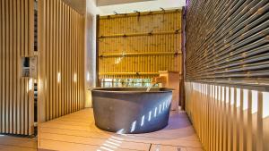 a large tub in a room with wooden walls at Stay SAKURA Tokyo Asakusa Yokozuna Hotel in Tokyo