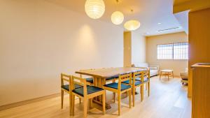 una sala da pranzo con tavolo e sedie in legno di Stay SAKURA Tokyo Asakusa Yokozuna Hotel a Tokyo