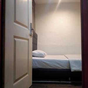 uma porta aberta para um pequeno quarto com uma cama em 1st Inn Hotel Glenmarie em Shah Alam
