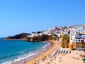 un grupo de personas en una playa cerca del océano en Apartamentos Tucha, en Albufeira