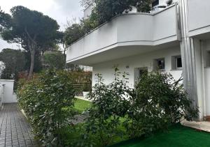 ein weißes Haus mit Büschen davor in der Unterkunft Residence La Settima in Milano Marittima