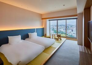 een hotelkamer met 2 bedden en een groot raam bij HOTEL AlaCOOJU OKINAWA in Minatogawa