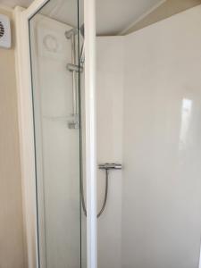 a shower in a bathroom with a glass door at 4 BEDROOMS CARAVAN at Waterside Leisure Holiday Park in Skegness