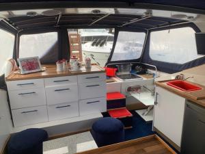 a kitchen with white cabinets and blue stools in an rv at Jade Flyer in Saltash