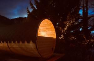a wooden barrel with a light on it at night at Brunnwirt ESSEN & WOHNEN in Fuschl am See